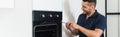 happy handyman repairing electric inbuilt oven Royalty Free Stock Photo