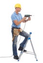 Happy, handyman and repairman in studio with a drill, tool belt and ladder for maintenance. Happy, smile and Royalty Free Stock Photo