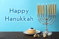 Happy Hanukkah. Silver menorah, dreidels and sufganiyah on wooden table against light blue background Royalty Free Stock Photo