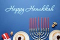 Happy Hanukkah. Traditional menorah, candles, sufganiyot and dreidels on blue background, flat lay Royalty Free Stock Photo