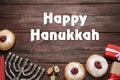 Happy Hanukkah. Traditional menorah, candles, sufganiyot and dreidels on wooden background, flat lay Royalty Free Stock Photo