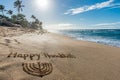 Happy Hanukkah written in the sand with a Hanukkiah