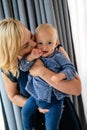 Happy family indoors. Portrait of beautiful mother with cute baby playing smiling together. Royalty Free Stock Photo