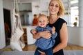 Happy family indoors. Portrait of beautiful mother with cute baby playing smiling together. Royalty Free Stock Photo