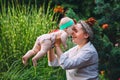 Happy harmonious family outdoors. mother throws baby up, laughing and playing in the summer on the nature. Royalty Free Stock Photo