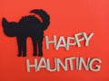 Happy haunting with a black cat silhouette on an orange background