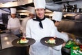 Happy head chef presenting his food plates