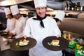 Happy head chef presenting his food plates Royalty Free Stock Photo