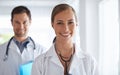 Happy health team. Portrait of two smiling doctors standing in a hospital. Royalty Free Stock Photo