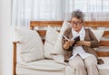 Happy & healthly retired smiling senior woman or pensioner reading book resting or sitting on couch or sofa at home. Eldery adult Royalty Free Stock Photo