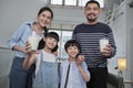 Happy healthy Asian parents and kids drink fresh milk together in the morning Royalty Free Stock Photo