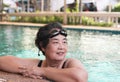 Happy and healthy Asian senior woman wearing swim goggles at swimming pool. Fit active senior woman enjoying retirement in Royalty Free Stock Photo