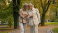 Happy healthy elderly senior mature Caucasian grandparents married man woman family couple walking holding hands outside Royalty Free Stock Photo