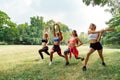 Happy healthy four beautiful young teenagers woman training and stretching for warming up before exercise in the park. fitness,