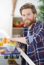 happy healthy handsome man making organic orange fruit juice