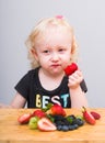 Happy kid  eating fresh strawberries Royalty Free Stock Photo