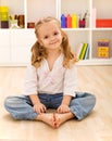 Happy healthy little girl sitting on the floor