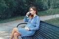 Pregnant young Caucasian woman wearing long blue dress and rustic country hat in park outside. Royalty Free Stock Photo