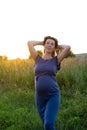 Happy healthy pregnancy and maternity. Portrait of pregnant young caucasian woman wearing long blue dress posing in park Royalty Free Stock Photo