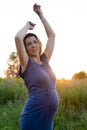 Happy healthy pregnancy and maternity. Portrait of pregnant young caucasian woman wearing long blue dress posing in park Royalty Free Stock Photo