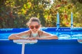 Happy healthy woman in swimming pool in sunglasses Royalty Free Stock Photo