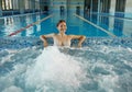 Happy young woman relaxing in hydro massage pool