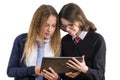 Happy high school friends closeup portrait. Teenage girls in school uniform on white background, with tablet, picture is isolated