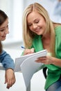 Happy high school student girls with note book