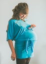 Portrait of a cute pregnant woman on a light background, at home