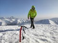 Happy hiker, climber in a beautiful mountainous scenery. Ice ax in the snow.