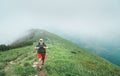 Happy hiker man walking by the cloudy and foggy weather mountain range path with backpack. Active sport backpacking healthy Royalty Free Stock Photo