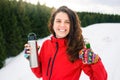 Happy hiker with thermos on snowy mountain