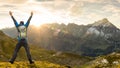 Successful Hiker Man with Backpack jumping with raised arms. Amazing sunrise in the mountains with nice lens flares and