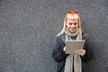 Happy hippie girl browsing a tablet working freelance and leaning on a wall of office building in the street. Hipster woman online Royalty Free Stock Photo