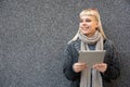 Happy hippie girl browsing a tablet working freelance and leaning on a wall of office building in the street. Hipster woman online Royalty Free Stock Photo