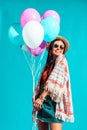 Happy Hippie girl holding colored helium balloons Royalty Free Stock Photo