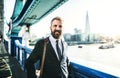 Hipster businessman walking on the bridge in London city. Royalty Free Stock Photo