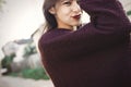 Happy hipster carefree girl in sweater walking in evening summer city. Stylish bohemian girl with funny emotions having fun and