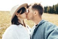 Happy hipster couple making selfie and kissing in sunny mountains. Stylish young family taking photo in travel and enjoying hiking Royalty Free Stock Photo