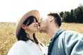Happy hipster couple making selfie and kissing in sunny mountains. Stylish young family taking photo in travel and enjoying hiking Royalty Free Stock Photo