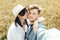 Happy hipster couple making selfie and kissing in sunny mountains. Stylish young family taking photo in travel and enjoying hiking Royalty Free Stock Photo