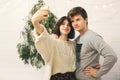Happy hipster couple taking selfie at modern christmas tree lights in stylish festive room. Celebrating Christmas or New Year`s Royalty Free Stock Photo