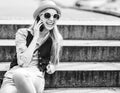 Hipster girl talking cell phone while sitting on stairs Royalty Free Stock Photo