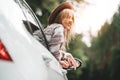 Happy hipster girl traveling adventure vacations. Boho woman sitting in car looking from window on view in country road