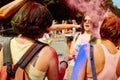 Happy hipster girls having fun with colorful powder at holi fest