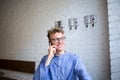 Happy hipster guy in casual wear having cellphone conversation during rest time in cafe. Royalty Free Stock Photo