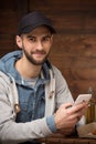 Happy hipster man sitting in the cafe with mobile phone Royalty Free Stock Photo