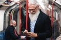 Happy hipster senior man watching smartphone in subway underground - Focus on face Royalty Free Stock Photo