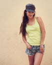 Happy hipster teen girl posing in hat and shorts outdoors Royalty Free Stock Photo