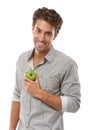 Happy with his diet. Portrait of a handsome young man holding an apple and smiing.